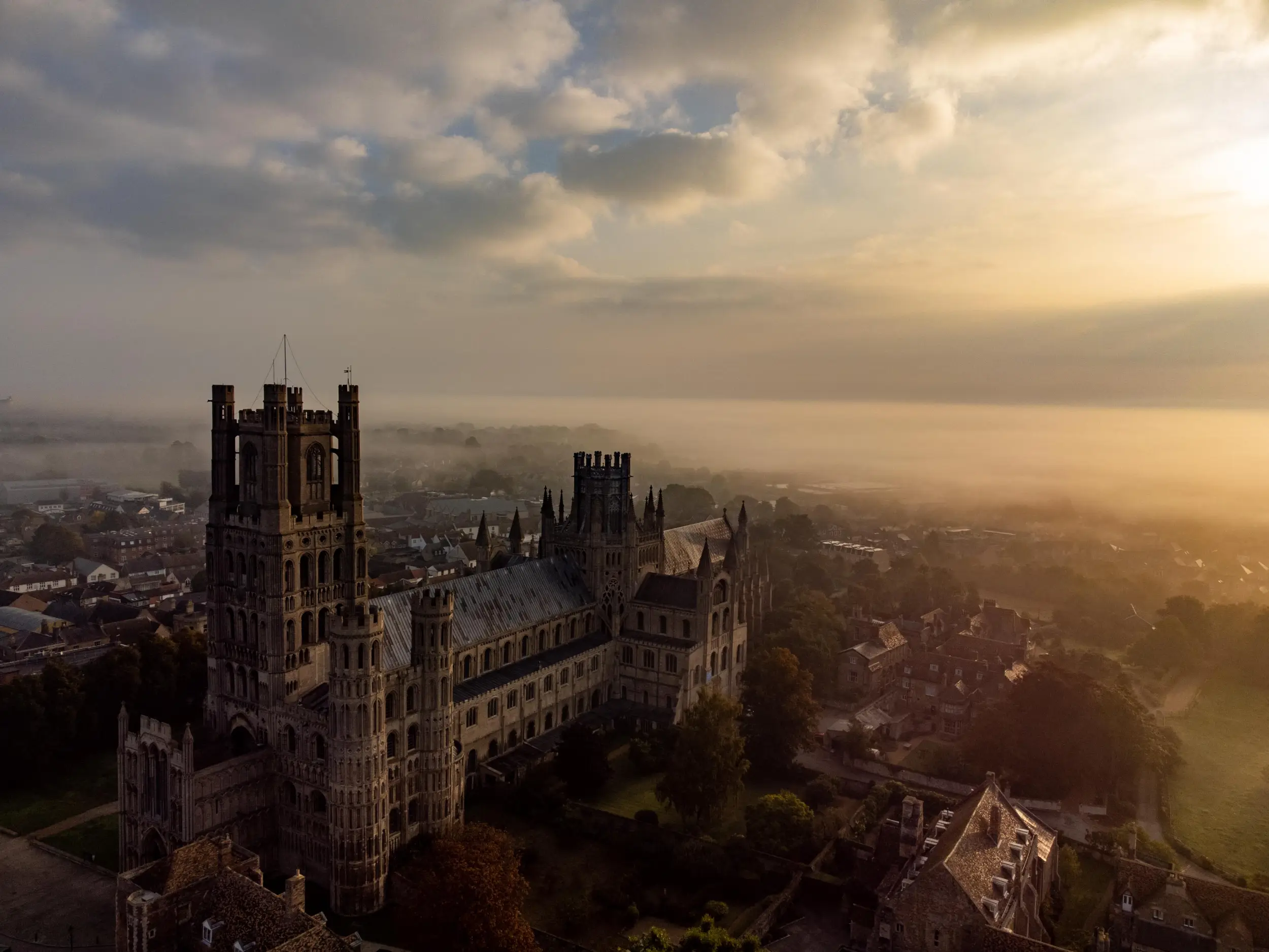 Ely Cathedral rising above the city in golden morning mist